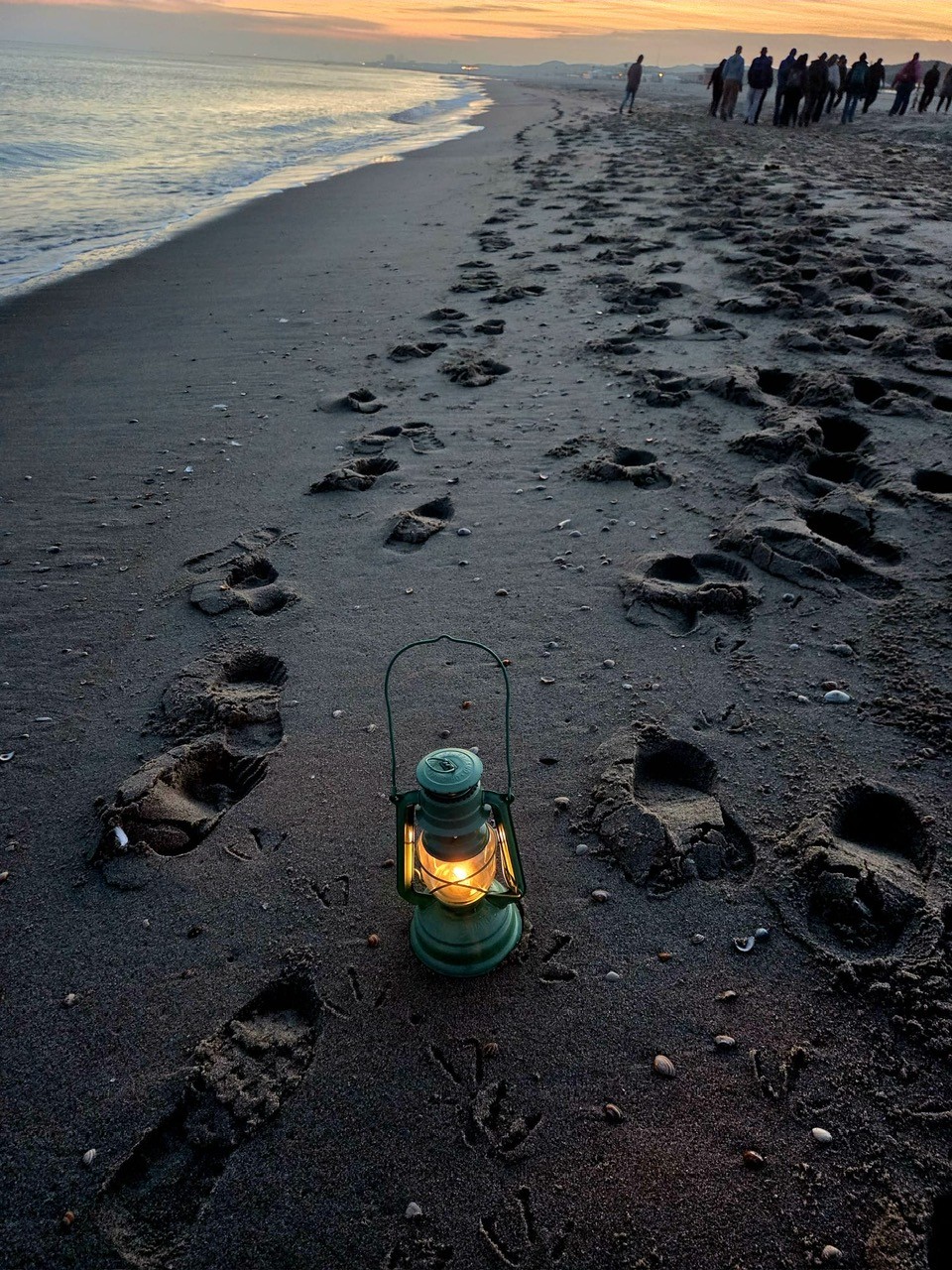 Voetstappen in het zand bij zonsopkomst